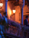 A couple shares a tender moment on Juliet's balcony under the twilight sky, embodying the timeless romance of Verona.