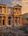 Early morning light bathes the Library of Celsus in Ephesus, highlighting the beauty of ancient architecture as visitors quietly engage with the site.