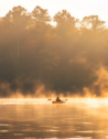 Sunrise at Lake Lanier, Georgia, featuring misty waters and a kayaker.