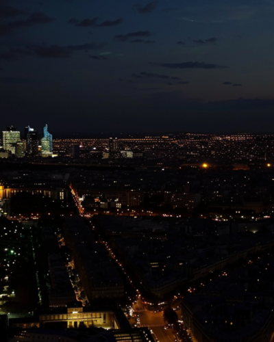 The illuminated Eiffel Tower at night, glowing against the dark sky in Paris