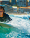 A joyful surfer rides the crisp blue waves in Sydney’s Bondi Beach.