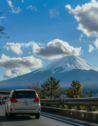 A car driving on a highway in Osaka, Japan with Mount Fuji in the background
