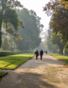 Two people walking along the pathways of Wilanow Palace in Warsaw, Poland