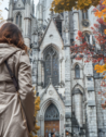Elegant traveler enchanted by Notre-Dame Basilica Montreal amid vibrant autumn.