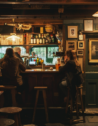 Locals in a cozy traditional pub in the Cotswolds, England.