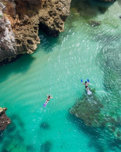 Snorkelers enjoy the vibrant underwater life near a secluded beach on a sunny day in Dunmore Town.